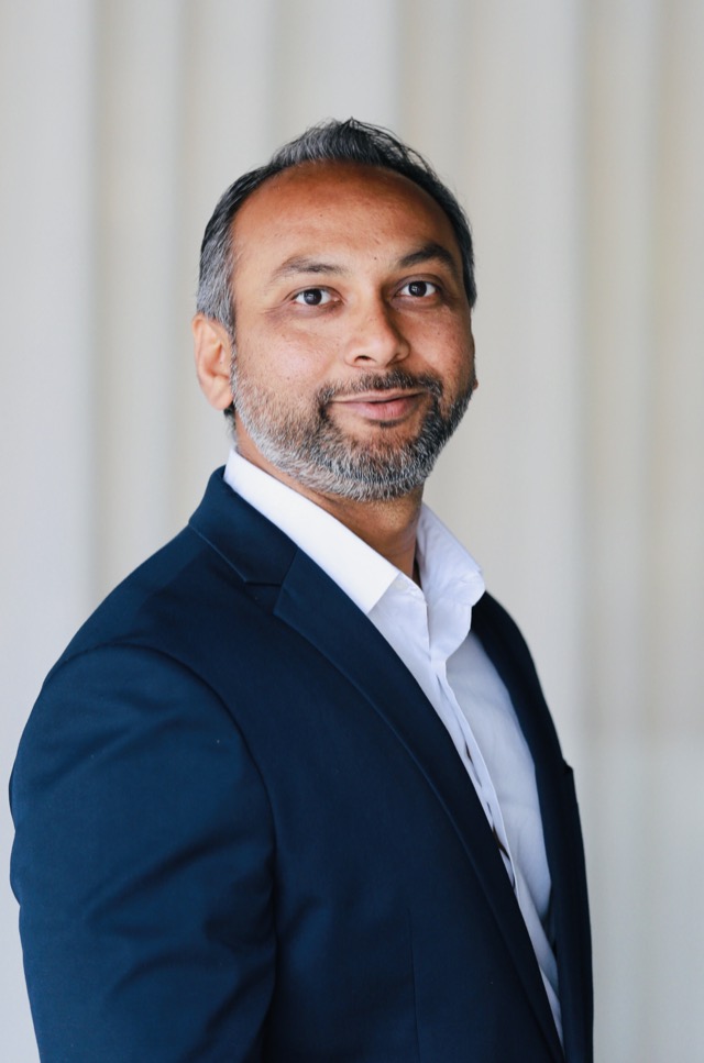 Anit Patel in a navy blazer, turned towards the camera